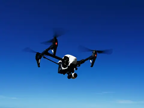 Drone flying against a deep blue sky
