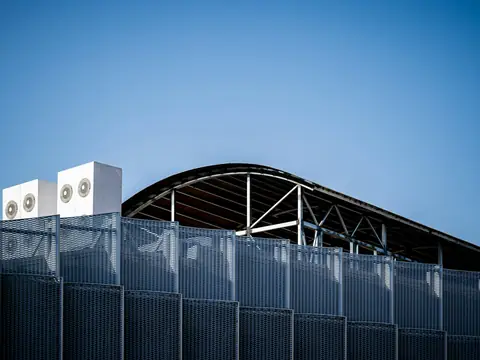 Rooftop HVAC units on a commercial building under a clear blue sky