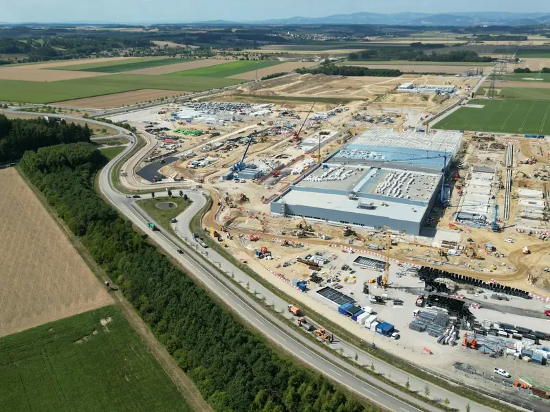 Aerial view of a large industrial construction site beside farmland